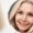 Happy mid aged woman looking at mirror. Antiaging beauty care concept.