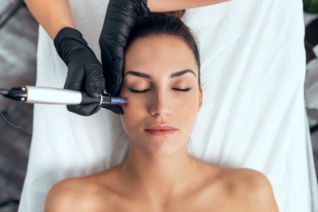Cosmetologist making mesotherapy injection with dermapen on face for rejuvenation on the spa center.