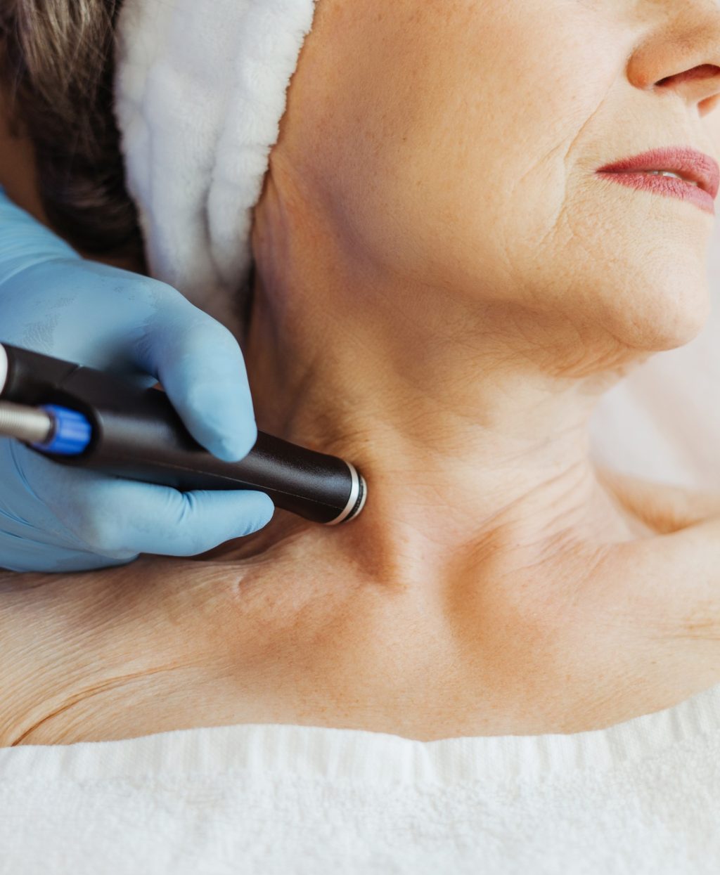 Closeup doctor cosmetologist doing cosmetic procedures, hydro facial on neck of older, elderly woman