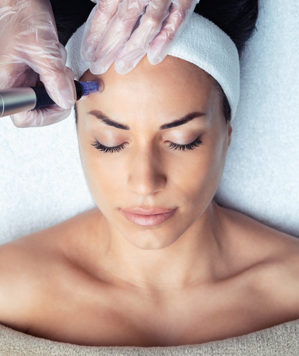 Cosmetologist making mesotherapy injection with dermapen on face for rejuvenation on the spa center.