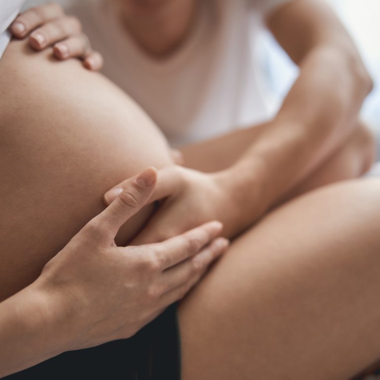 Future mom and dad are touching pregnant tummy