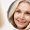 Happy middle aged woman looking at mirror. Antiaging beauty care concept.