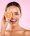 Happy woman, portrait and grapefruit on face for vitamin C nutrition or natural skincare against a