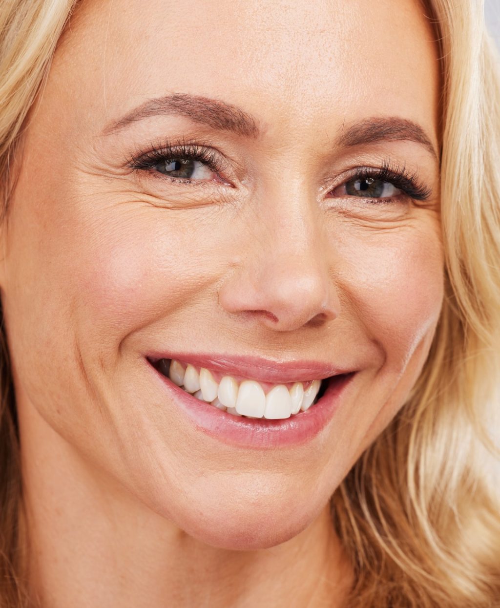 Portrait, skincare and happy with a woman in studio on a gray background for beauty or antiaging tr
