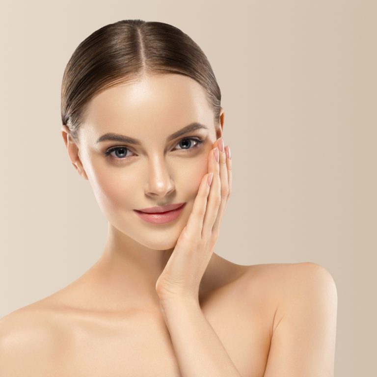 Woman face beauty hand touching face healthy natural makeup female beige background