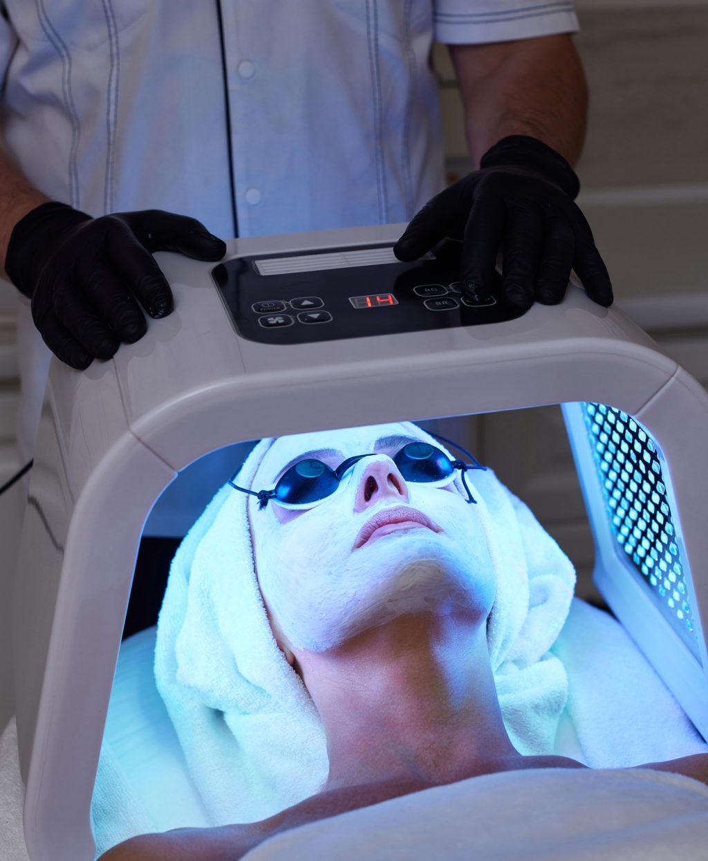 Woman getting facial treatment with led therapy.